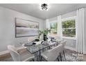 Modern dining room with glass table and neutral decor at 6762 Glenmoor Dr, Charlotte, NC 28214