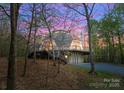 Charming home with a wrap-around deck, nestled among the trees at dusk at 10200 Amsterdam Dr, Mount Pleasant, NC 28124