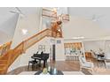 Bright living room with cathedral ceilings, hardwood floors, spiral staircase and piano at 10200 Amsterdam Dr, Mount Pleasant, NC 28124
