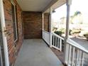 View of the covered front porch with white railings and brick accents, perfect for outdoor relaxation at 110 Robin Rd, Lincolnton, NC 28092