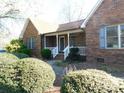 Inviting brick home featuring a covered front porch with classic white railings and charming curb appeal at 110 Robin Rd, Lincolnton, NC 28092