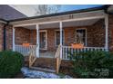 Brick front porch with white railings, planters, and a wooden front door at 110 Robin Rd, Lincolnton, NC 28092