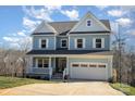 Two-story light blue house with white shutters, double garage, and landscaped yard at 12060 Mariners Cove Ct, Lancaster, SC 29720