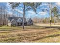 House nestled among trees with a large grassy yard at 200 Barra Dr, Waxhaw, NC 28173