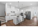 Bright kitchen featuring white cabinets, stainless appliances, island with seating, and hardwood floors at 3113 Beacon Heights Rd, Indian Land, SC 29707