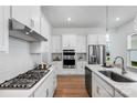 Modern kitchen with white cabinets, stainless steel appliances, sleek island with seating, and tiled backsplash at 3113 Beacon Heights Rd, Indian Land, SC 29707