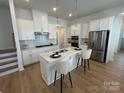 Bright kitchen features white cabinets, quartz countertops, pendant lights, and stainless steel appliances at 3113 Beacon Heights Rd, Indian Land, SC 29707