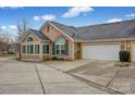 Rear view of home showcasing attached garage and sunroom at 4829 Boomerang Way, Charlotte, NC 28269