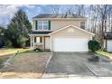 Tan two-story house featuring a white garage door and small front yard at 509 Tallwood Ct, Charlotte, NC 28216