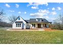 White farmhouse with a wraparound porch, and landscaped yard at 535 Grampian Rd, Mt Ulla, NC 28125