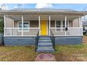 Charming house with a yellow door, front porch, and gray siding at 639 Harrison St, Statesville, NC 28677