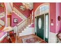 Elegant foyer featuring a chandelier, staircase, and decorative front door, offering a welcoming entrance at 1000 Weeping Willow Ln, Matthews, NC 28105