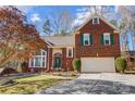 Lovely brick home featuring a two-car garage, landscaped front yard, and traditional architectural details at 1000 Weeping Willow Ln, Matthews, NC 28105