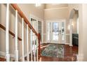 Two-story foyer with hardwood floors, a chandelier, and a staircase at 11925 Lawings Corner Dr, Huntersville, NC 28078