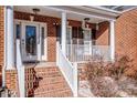 Brick front porch with white columns, steps, and a glass front door at 11925 Lawings Corner Dr, Huntersville, NC 28078