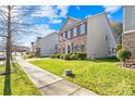 Two-story house with manicured lawn and sidewalk at 13026 Serenity St, Huntersville, NC 28078