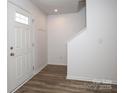 Bright foyer with wood-look floors, coat rack, and stairs at 1812 Hooper Ct, Charlotte, NC 28212