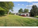 Expansive backyard with lush green grass and mature trees, offering plenty of space for outdoor activities at 1901 Ashcraft Ave, Monroe, NC 28110