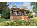 Welcoming brick home featuring a covered porch with metal railings, perfect for enjoying the outdoors at 1901 Ashcraft Ave, Monroe, NC 28110