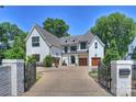 Luxury home with a white brick facade, gated entry, and a spacious driveway at 2714 Selwyn Ave, Charlotte, NC 28209