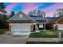 Charming home featuring a stone facade, white garage door and a manicured lawn at 629 Cordova Ct, Salisbury, NC 28146