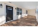 Inviting front porch with black front door at 646 Central Nw Dr, Concord, NC 28027