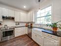 Modern kitchen with white cabinets, farmhouse sink, and dark countertops at 6706 Blackwood Ln, Waxhaw, NC 28173