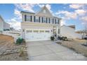 Two-story house with gray siding, white trim, and a three-car garage at 7067 Waterwheel Sw St, Concord, NC 28025