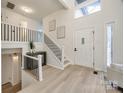 Bright and airy entryway with modern staircase and light wood floors at 7137 Windyrush Rd, Charlotte, NC 28226