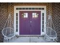 Purple double front doors with sidelights and hanging chairs at 7236 Albemarle Dr, Denver, NC 28037