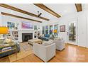 Open living room with hardwood floors, exposed beams, and a fireplace at 832 Heather Ln, Charlotte, NC 28209