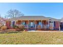 Brick house featuring a covered porch and well-maintained lawn at 116 Country Creek Dr, Kings Mountain, NC 28086