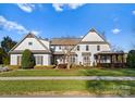 Two story home with white siding, a covered porch, and neatly landscaped lawn at 13505 Evening Primrose Dr, Davidson, NC 28036