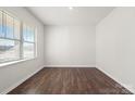 Simple bedroom with dark hardwood floors and a window with blinds at 221 Wildflower Dr, Locust, NC 28097