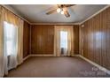 Living room with wood paneling, carpet, and two windows at 304 Edel St, Kings Mountain, NC 28086