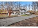 Two-story home with a covered porch, American flag, and long driveway at 4501 Brookwood Rd, Charlotte, NC 28215