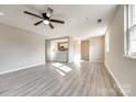 Spacious living room features hardwood floors, a ceiling fan, and natural light at 4901 Smokehollow Rd, Charlotte, NC 28227