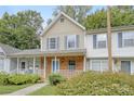 Tan and brick townhouse with blue shutters and a walkway at 6325 Windsor Gate Ln, Charlotte, NC 28215