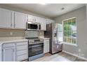 Modern kitchen featuring white cabinets, stainless steel appliances, and quartz countertops at 6325 Windsor Gate Ln, Charlotte, NC 28215