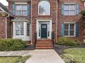 Brick front entrance with a dark green door and steps leading to the walkway at 8839 Blooming Arbor St, Huntersville, NC 28078