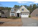 Two-story house with neutral siding, white garage door, and landscaping at 116 Van Gogh Trl, Mount Holly, NC 28120