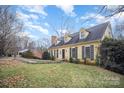 Side view of a yellow house with mature trees and landscaping at 1346 5Th Street Nw Cir, Hickory, NC 28601