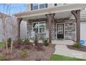 Front porch with rocking chairs and stone details at 146 Dogwood Grove Pl, Troutman, NC 28166