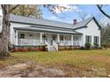 White farmhouse with wrap-around porch and mature trees at 2633 Jb Denton Rd, Lancaster, SC 29720