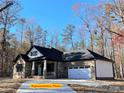 Brick house with a dark roof, two-car garage, and a landscaped yard at 305 General As Johnston St, Stanley, NC 28164