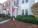 Townhome with brick and siding, American flag, and well-maintained landscaping at 6012 Sapwood Ct, Matthews, NC 28104