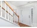 Bright entryway with wooden staircase and white front door at 9005 Jaldena Dr, Charlotte, NC 28227