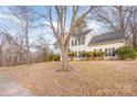 Two-story house with gray siding, dark shutters, and a tree in the front yard at 9005 Jaldena Dr, Charlotte, NC 28227