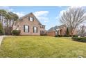 Two-story brick homes on a grassy lot with mature trees at 9729 Cockerham Ln, Huntersville, NC 28078