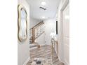 Hallway with staircase, decoratively framed mirror, modern lamp and wooden floors at 1229 Kohler Ave, Charlotte, NC 28206